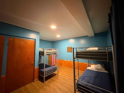 two bunk beds in a room with blue walls at Raymi House Hostel in Arica