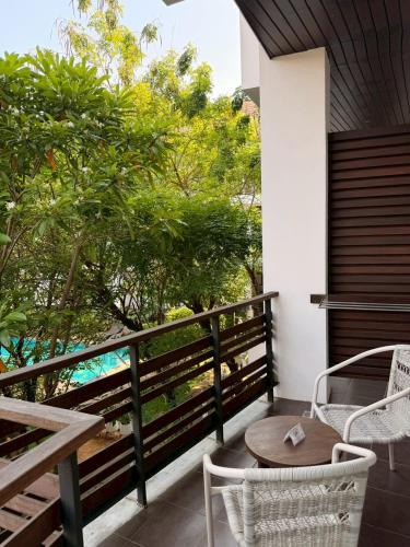 ein Balkon mit Tisch und Stühlen und Bäumen in der Unterkunft Le Patta Resort & Hotel Chiang Rai in Chiang Rai