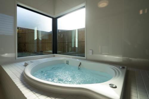 a bath tub in a bathroom with a window at URADO TERRACE Private villa 無料駐車場4台 最大10名 桂浜近く ジャグジー シアタールーム完備 in Kochi
