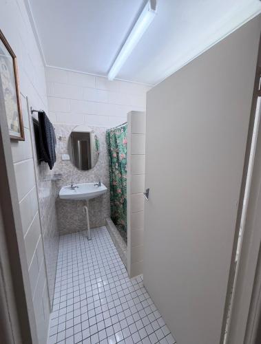 a bathroom with a sink and a mirror at Tropical City Motor Inn in Ayr