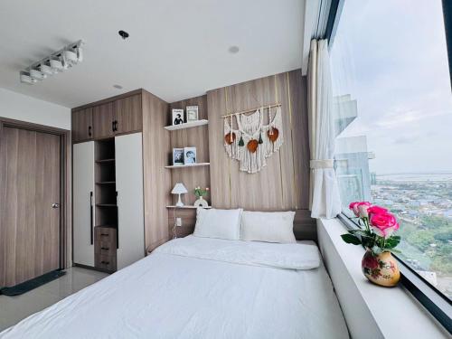 a bedroom with a large white bed and a window at AC Nera Garden Apartment in Thôn Văn Dương