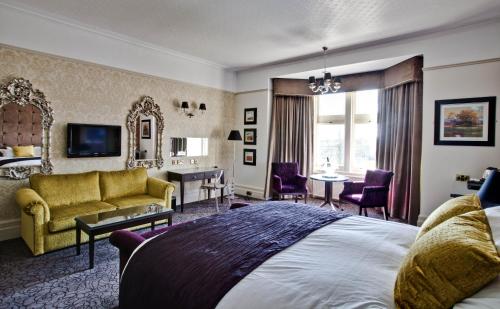 a bedroom with a large bed and a living room at Pontlands Park Hotel in Chelmsford