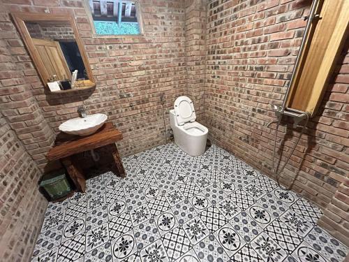 a bathroom with a white toilet and a sink at ANOR - Farmstay - Double bed in Ha Tia