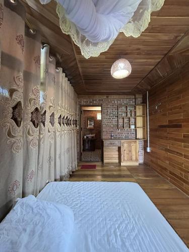 a bedroom with a large bed with a curtain at ANOR - Farmstay - Double bed in Ha Tia