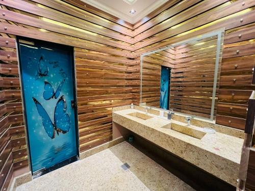 a bathroom with two sinks and a wooden wall at Dreams Garden VIP Villa in Sphinx International Airport