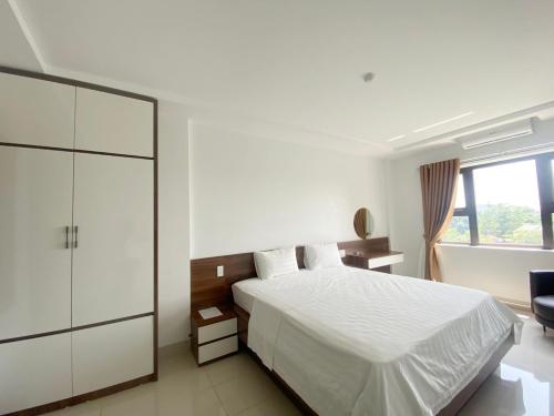 a bedroom with a white bed and a window at Khách sạn Ruby - Gần trung tâm khảo thí in Cầu The