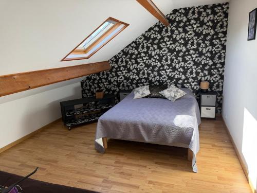 a bedroom with a bed and a black and white patterned wall at Le petit cocon in Brêmes