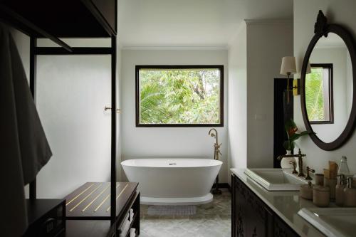 a bathroom with a large tub and a window at Hotel Kiridara Luang Prabang in Luang Prabang