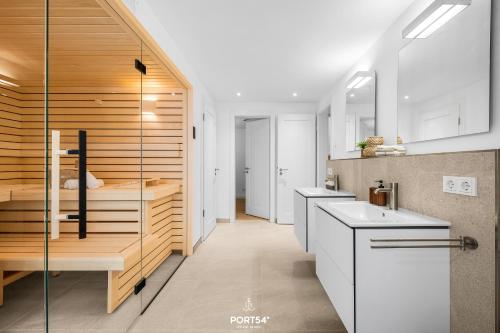 a kitchen with white cabinets and a glass wall at Villa Tinnum Sylt in Tinnum