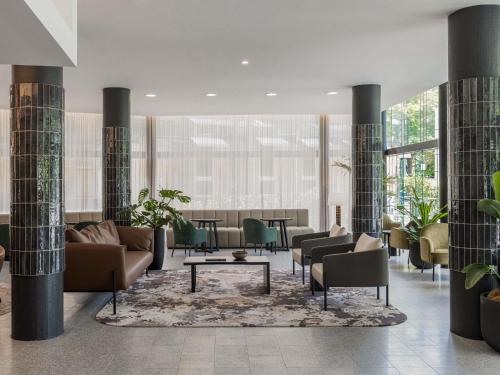 a lobby with couches and chairs and a table at Mercure Brisbane Spring Hill in Brisbane