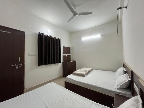 a small room with two beds and a window at Hotel Dayalu palace in Vrindāvan