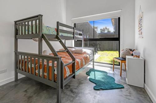 a bedroom with two bunk beds and a rug at Sheoak in Paynesville
