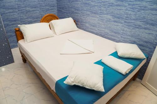 a bed with white sheets and pillows next to the ocean at Risha villa in Trincomalee