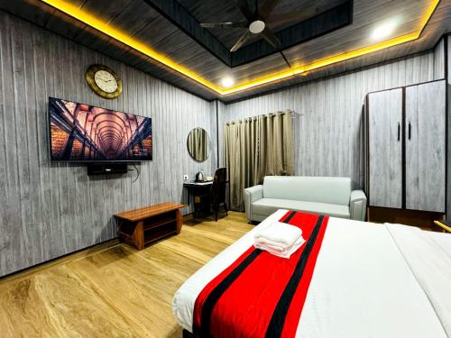a bedroom with a bed and a tv on a wall at HOTEL N K RESIDENCY in Guwahati