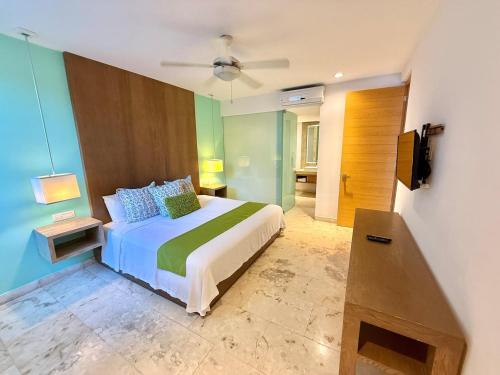a bedroom with a bed and a television in it at Anah Suites by Las Flores Vacation Rentals in Playa del Carmen