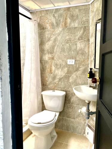 a bathroom with a toilet and a sink at BORA, Apto 301 Tu Espacio Fuera de Casa in Ibagué