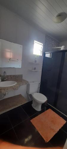 a bathroom with a toilet and a sink at O Pouso Condomínio in Mucugê