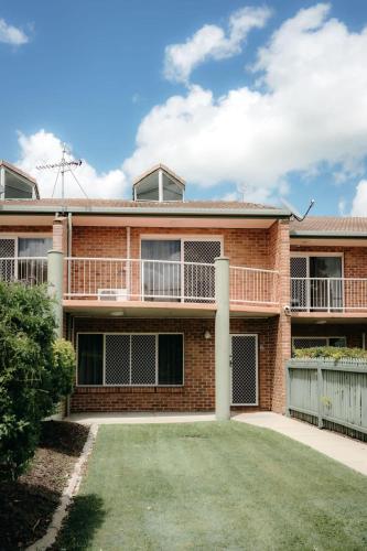 a brick house with a lawn in front of it at Unit 2, Rocky CBD in Rockhampton