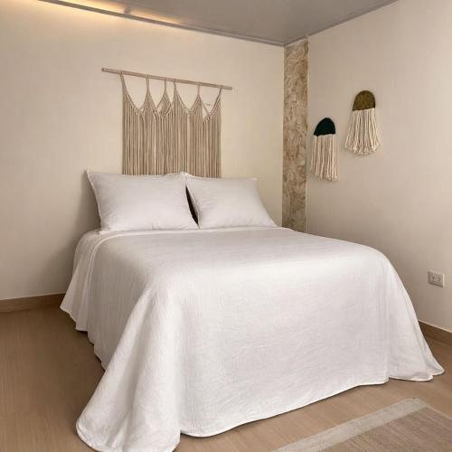 a bedroom with a white bed with white sheets at BORA, Apto 301 Tu Espacio Fuera de Casa in Ibagué