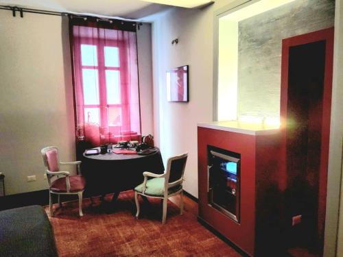 a living room with a table and a fireplace at Le Cœur Urban Suite Parma in Parma