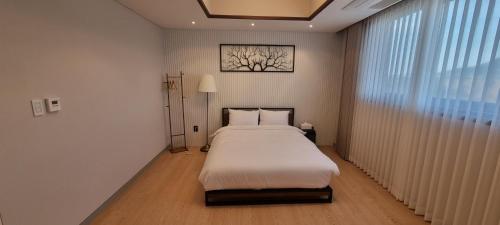 a bedroom with a large bed and a window at Miracle Suite House 1 in Incheon
