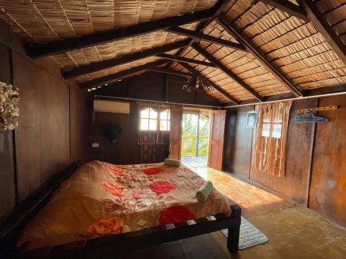 a bedroom with a bed in the middle of a room at Beach Shack Tioman - Beachfront Seaview in Tioman Island