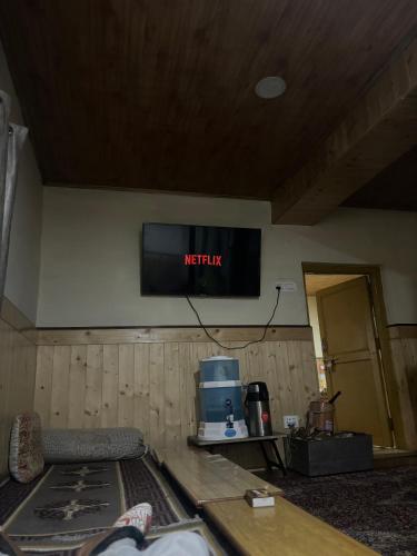 a television hanging on the wall of a room at Dungkhar homestay in Kaza