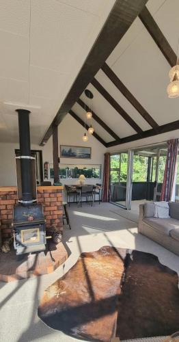 a living room with a fireplace and a couch and a stove at Waypoint Lodge in Naseby