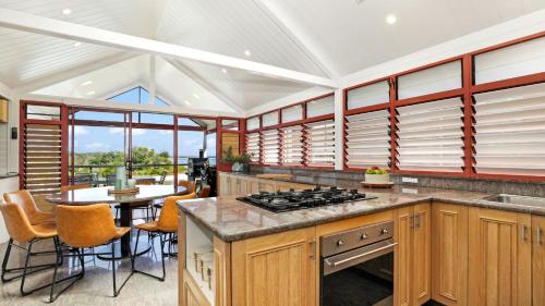 a kitchen with wooden cabinets and a table with chairs at Sea Light in Currarong