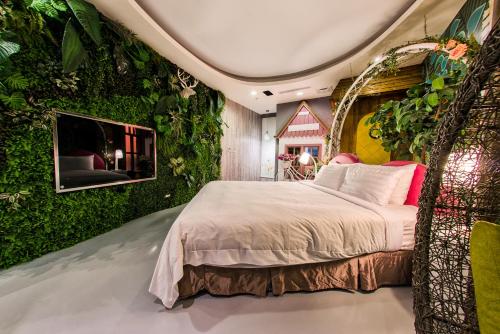 a bedroom with an ivy covered wall with a bed at AmanCity Motel in Pingtung City