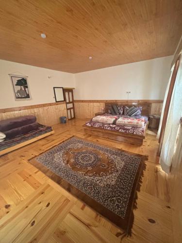 a bedroom with a bed and a rug on a wooden floor at Dungkhar homestay in Kaza