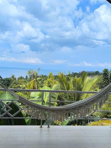 a bridge on a building with palm trees in the background at Villa Archie INCREDIBLE Sea View second fl in Ko Phangan
