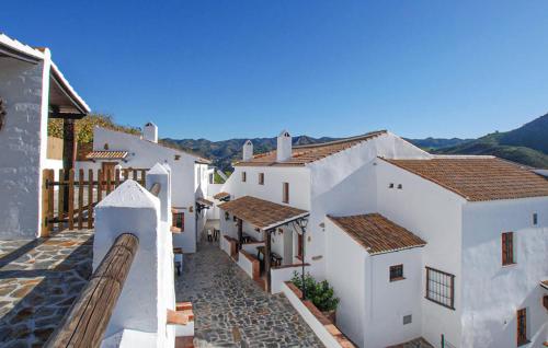 a row of white buildings with mountains in the background at La Casa Grande in Málaga