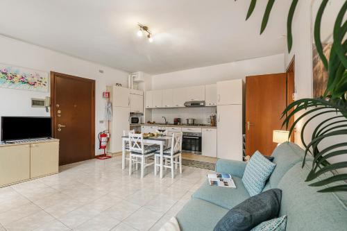 a living room with a blue couch and a kitchen at Petalo Bianco: 100m from Lake, Parking and Balcony - Happy Rentals in Baveno