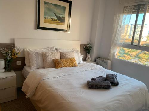 a bedroom with a large white bed with pillows at Cabo Mar in El Campello