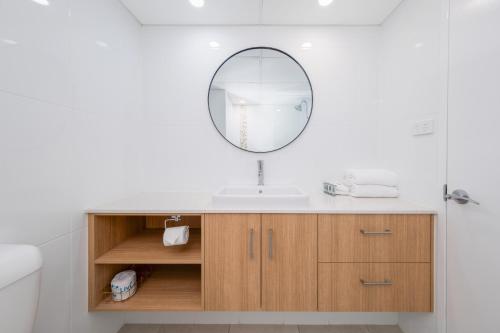 ein Badezimmer mit Waschbecken und Spiegel in der Unterkunft Bayview Tower in Yeppoon