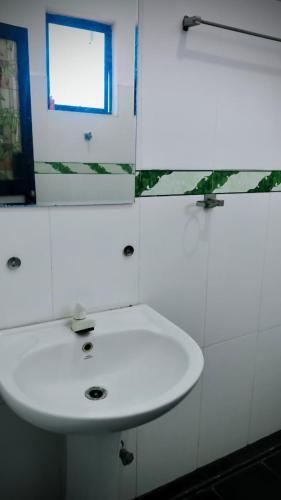 a bathroom with a white sink and a window at Nilaveli Better Beach Resort in Nilaveli