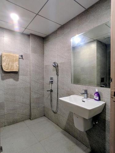 a bathroom with a sink and a shower with a mirror at Comfort Corner in Greater Noida