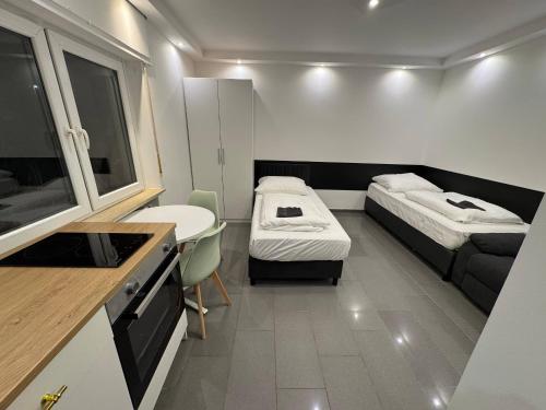 a small room with two beds and a kitchen at Studio Apartment next to Airport in Kelsterbach