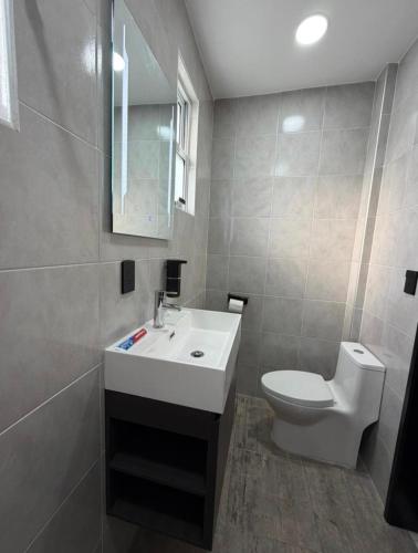 a bathroom with a white sink and a toilet at Casa Azteca de Oro in San Sebastian Xolalpa