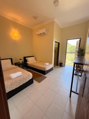 a bedroom with two beds and a balcony at Summer village in Kampong Pasir Hantu