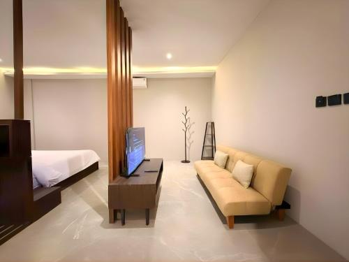 a living room with a couch and a bed at The W Avenue in Bandung
