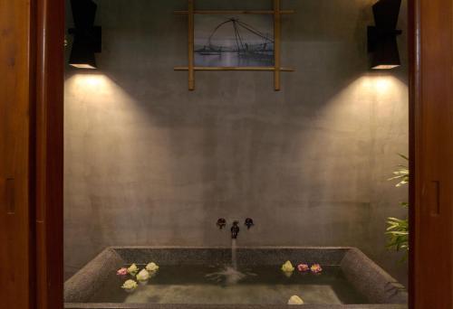 a bathroom with a bath tub with a fountain at La Rivière d' Angkor Resort in Siem Reap