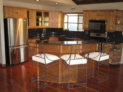 a kitchen with a island with chairs and a refrigerator at Alta Peak Vista in Three Rivers