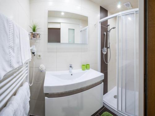 a white bathroom with a sink and a shower at Aparthotel Gallahaus in Zell am Ziller