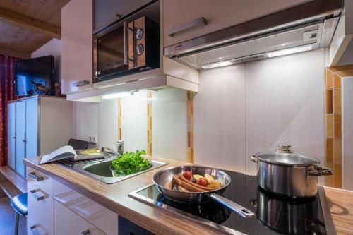 a kitchen with a bowl of vegetables on the stove at Aparthotel Gallahaus in Zell am Ziller