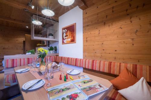 a dining room with a table and a wooden wall at Aparthotel Gallahaus in Zell am Ziller