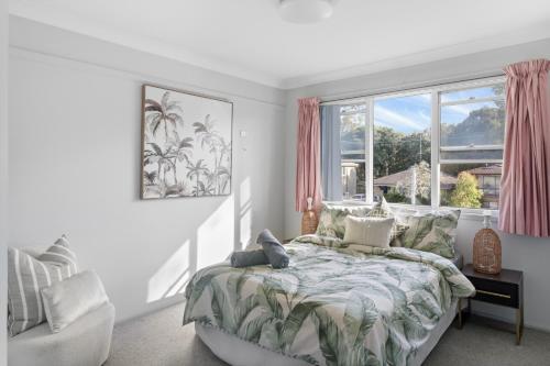 a bedroom with a bed and a large window at River Retreat in Dora Creek