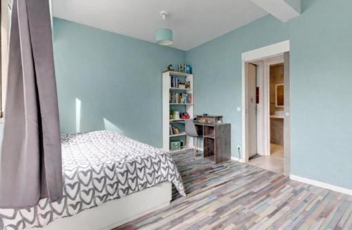 a bedroom with a bed and a blue wall at La Lanterne Plage in Nice