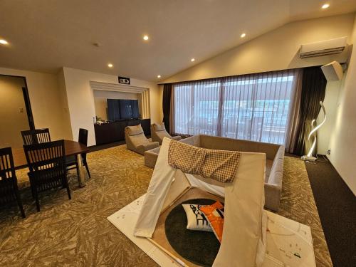 a living room with a couch and a dining room at Hotel Grand Vert Kyu Karuizawa in Karuizawa